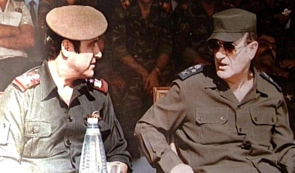 Rıfat Esad 1984'te dönemin devlet başkanı ağabeyi Hafız Esad'la yan yana. The Daily Telegraph'ın haberinde Beşşar Esad'ın "rejime yakın çevreyi" bir arada tutmakta zorlandığı da ileri sürüldü. Suriye savaşında İran'ın oynadığı rolün tartışmalara neden olduğuna da dikkat çekildi. İranlı yetkililerin, hükümetten merkez bankasından savaş stratejilerine kadar geniş alanlarda komutayı ellerine aldıkları iddialarına da yer verildi.