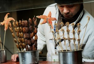 A hawker sells scorpions, star fish, sea